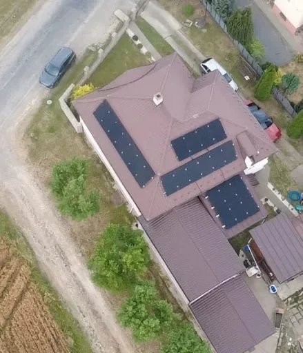 Letecký pohľad na štyri polia solárnych panelov na členitej streche rodinného domu v Pavlovciach nad Uhom