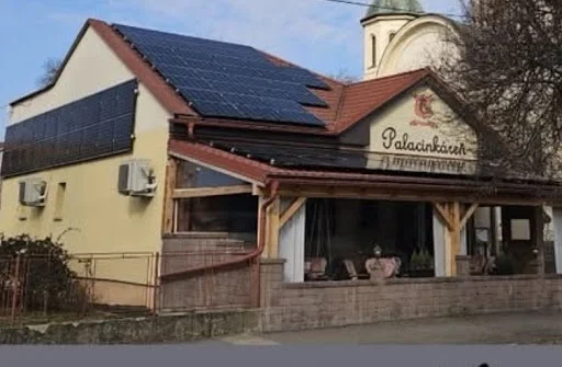Dva rady solárnych panelov na šikmej streche budovy s palacinkárňou